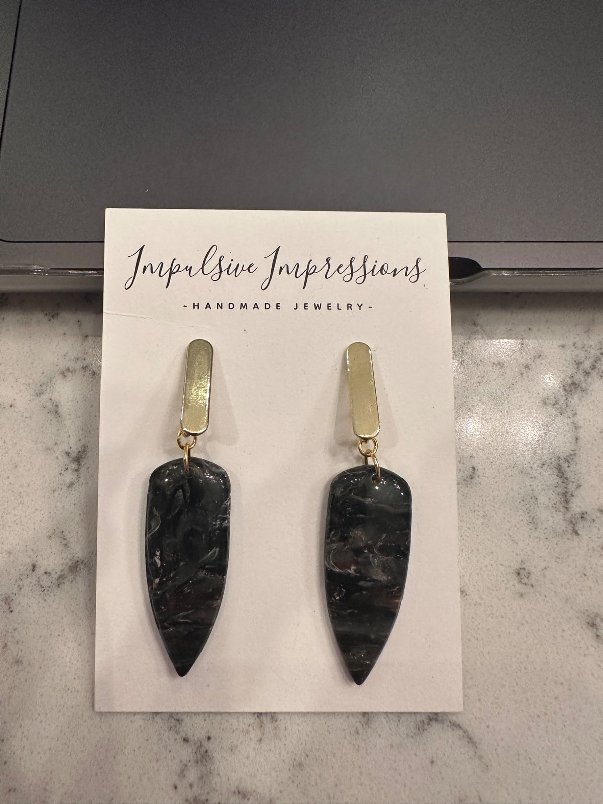 Black marbled pointed polymer clay drop earrings with elongated gold-tone studs