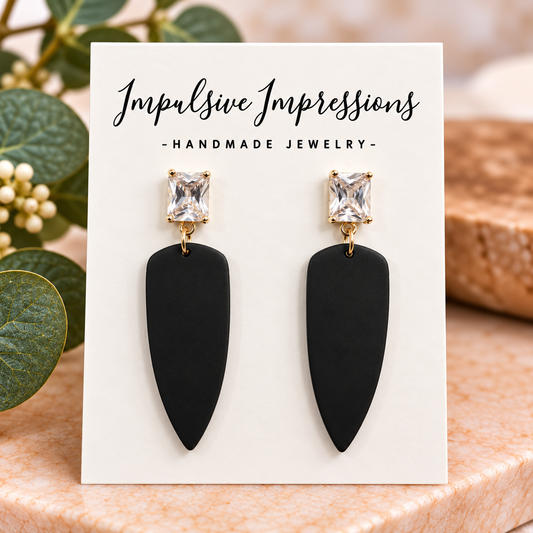 Black polymer clay pointed drop earrings with clear rectangular crystal studs