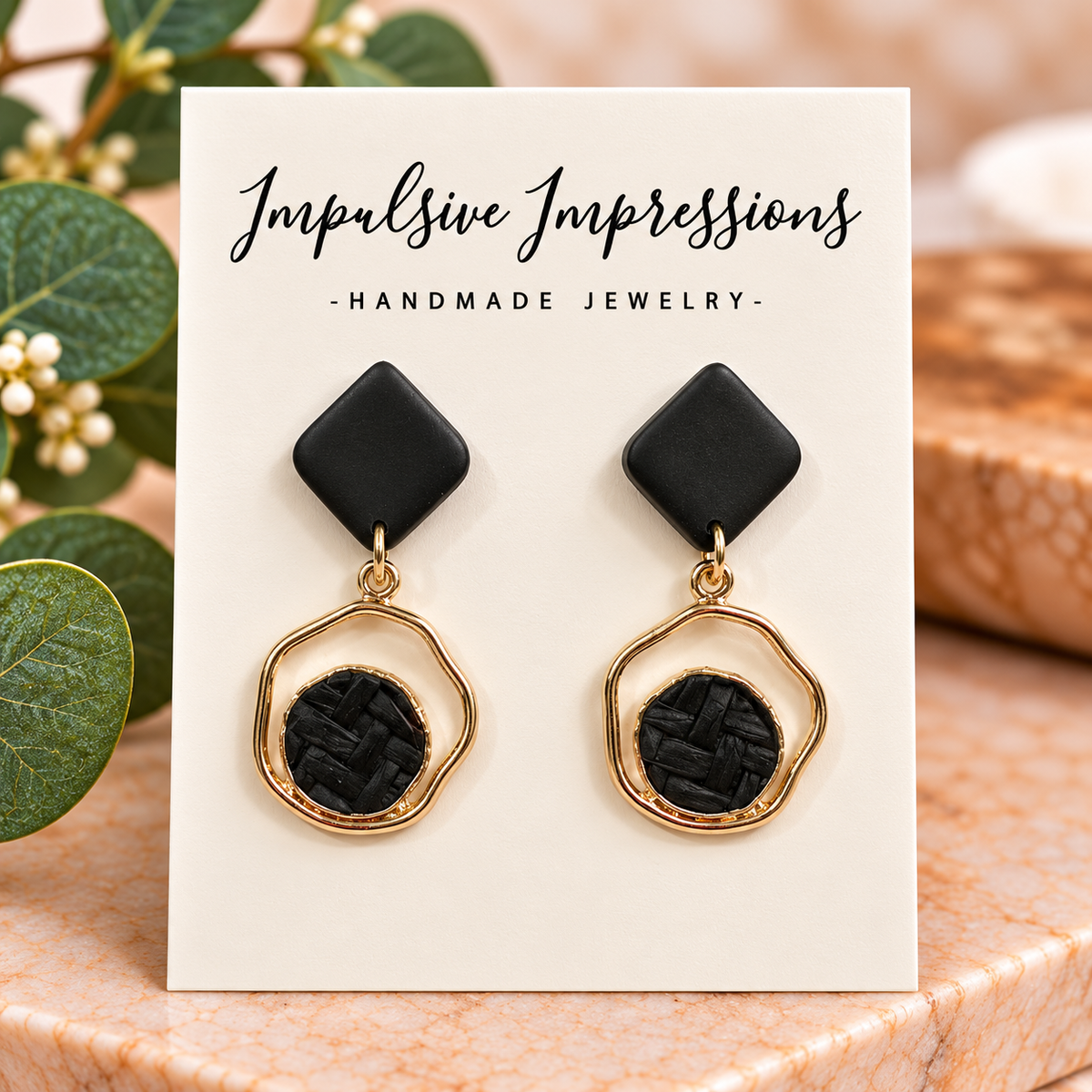 Black diamond polymer clay stud earrings with gold geometric frames and textured black centers