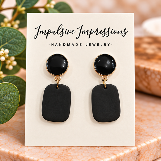 Black matte polymer clay rounded rectangular earrings with glossy black gold-rimmed studs