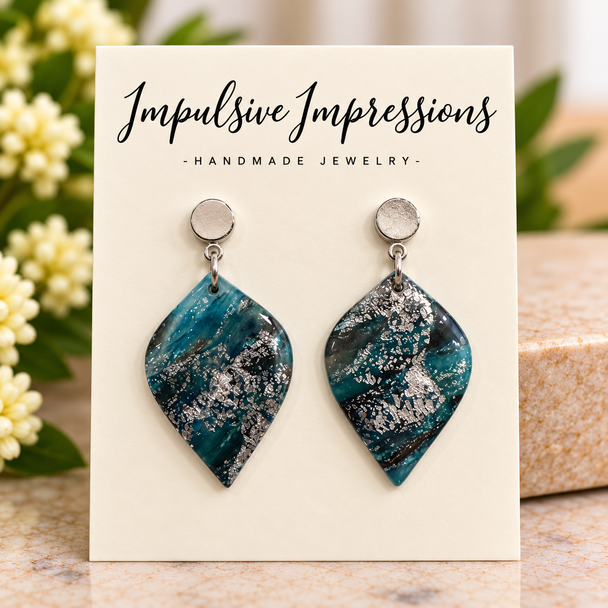 Teal marbled polymer clay leaf earrings with silver-colored foil accents